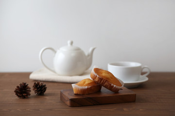 木のテーブルにのせた カップケーキ 紅茶 ティー ポット カップ