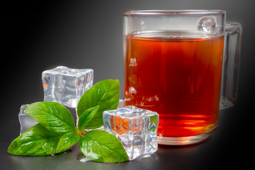 A mug of tea on a black background, and next is a green mito