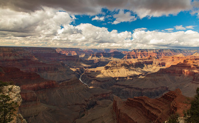 Panorama wide shot of the grand canyon with clouds and blue sky