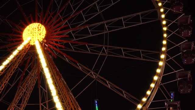 Beautiful flashing lights blurred illumination colorful bokeh of huge ferris wheel at amusement park at night background