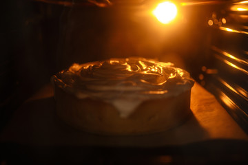 Lemon meringue pie on cutting board on brown wooden background