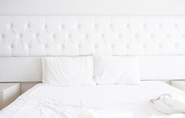 White bedroom interior design with bed and blank pillows. Bedding relax time. Copy space