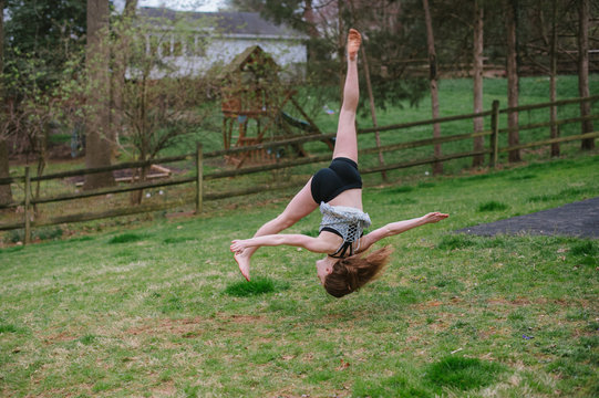 girl doing gymnastics in the back yard.
