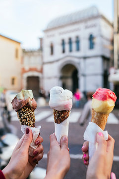 Friends holding icecreams on the street