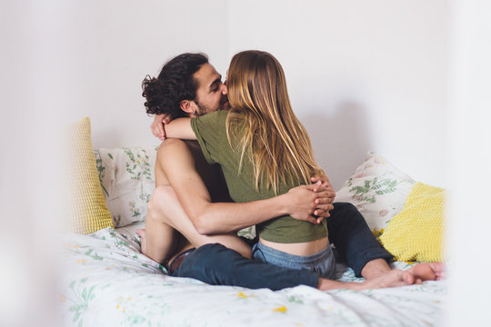 Young Heterosexual Couple Hugging In Bed