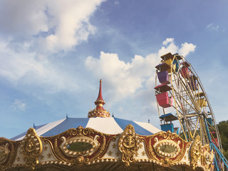 Top of a carnival carousel or merry-go-round and a ferris wheel.