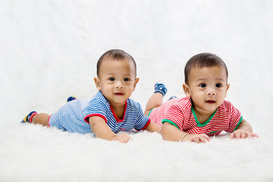 Infant twins sleeping.Newborn Babies Twins Sleep in Bed.Lovely sleep of the newborns babies on the bed. Cute twins baby boy is shooting in the studio. fashion image of baby and family. 
