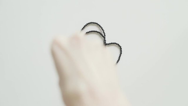 Woman puts her black beads on the table in a circle