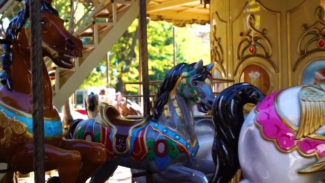 Gorgeous close up shot of retro circus carousel vintage merry go round horse ride attraction spinning at amusement park