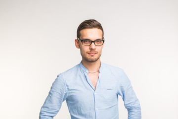 Handsome confident serious man in glasses standing on white background
