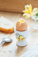 Egg in a egg cup and toast on a wooden table