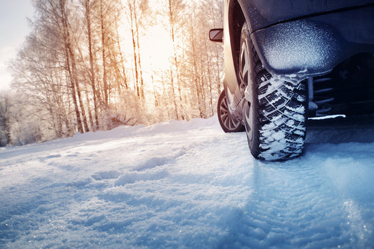 Car tires on winter road covered with snow. Snowy landscape with a vehicle