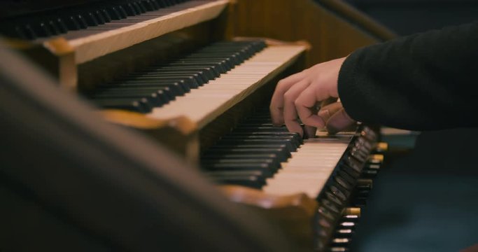 Detail of a man playing a church organ.