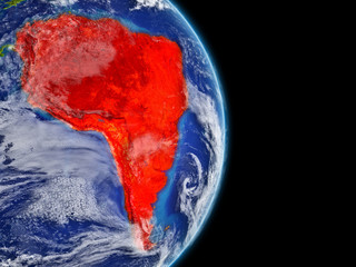 South America on planet Earth with highly detailed planet surface and clouds. Continent highlighted in red.