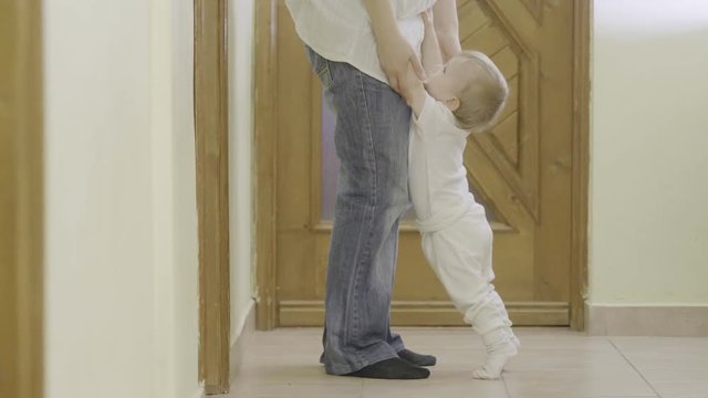 Spoiled baby pull on mother feet