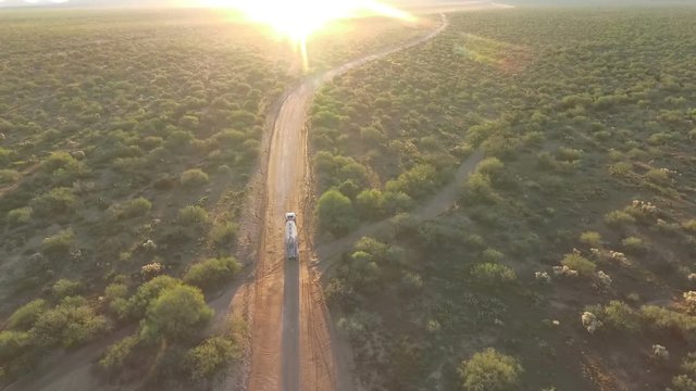Aerial of a semi truck heading into the morning sun