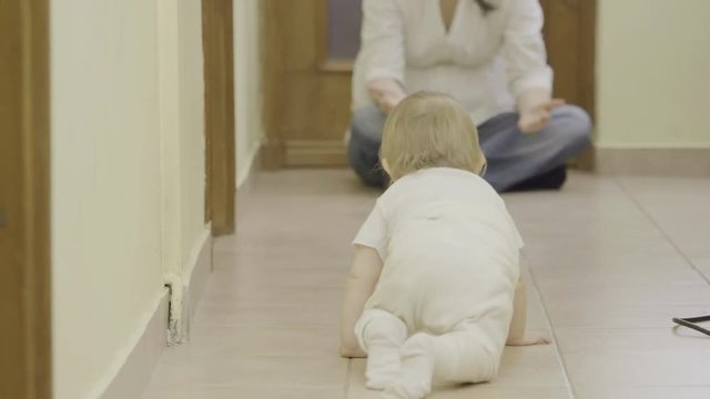 Lovely baby crawling to his mother arms, sweet embrace