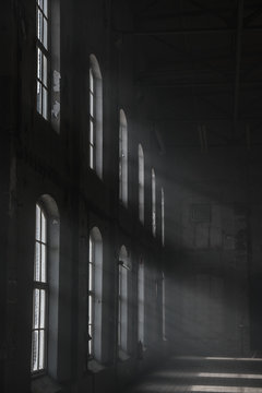 Sunlight shining throuh the windows of an old abandoned industrial warehouse building