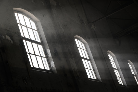Sunlight shining throuh the windows of an old abandoned industrial warehouse building