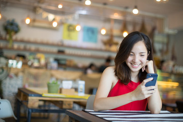 woman with beautiful smile reading good news on mobile phone during rest in coffee shop