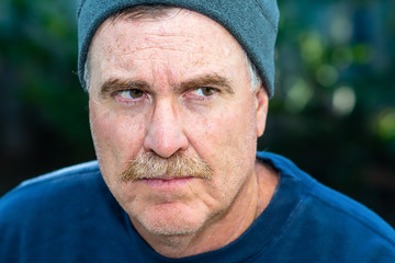 portrait of senior man looking to away with angry expression