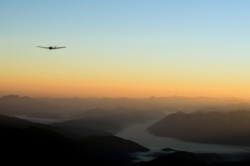 Fototapeta na wymiar Sunrise in the alps with glider plane