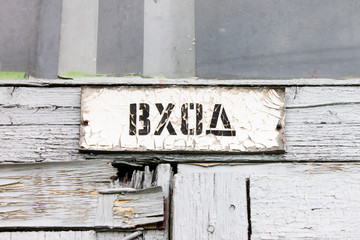 Part of wooden door with inscription in russian "entrance"