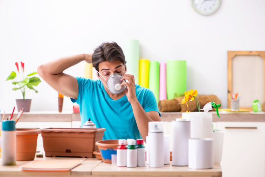 Young man decorating pottery in class - Powered by Adobe