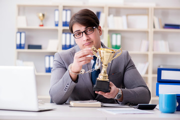 Businessman with golden cup in the office