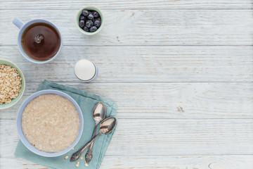 Fototapeta na wymiar Oatmeal porridge bowl on the white wooden background.