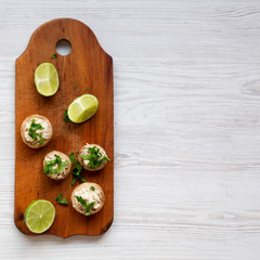 Mushroom and chicken puree with lime on rustic wooden board, overhead view. White wooden surface. Flat lay, from above, top view. Copy space.