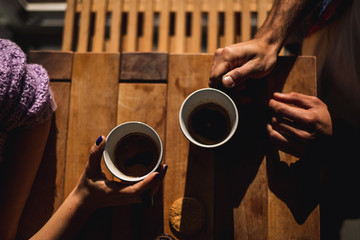Fototapeta na wymiar Couple holding cups of coffee on the table