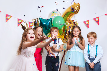 Group of adorable kids having fun at birthday party - obrazy, fototapety, plakaty