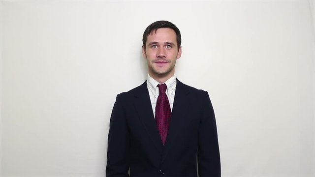 Young beautiful businessman in blue suit smiling and waving her hand greeting customers.Portrait on a white background.