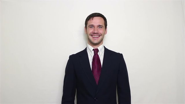 Young beautiful businessman in blue suit smiling and waving her hand greeting customers.Portrait on a white background.