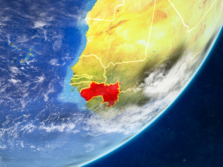 Guinea on model of planet Earth with country borders and very detailed planet surface and clouds.