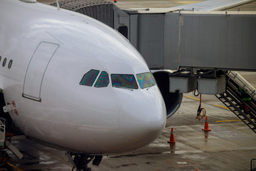 Airliner being prepared for boarding and takeoff on airport docked to terminal and serviced