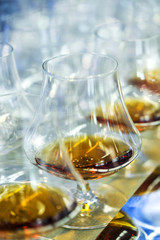 Integration meeting. A glass of alcohol whiskey, cognac or brandy on the table with a blue tint on the table. Soft focus, Macro.