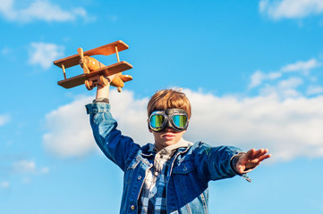 Fashionable teenager in pilot glasses with an airplane in his hands. Concept purpose, adventure,...