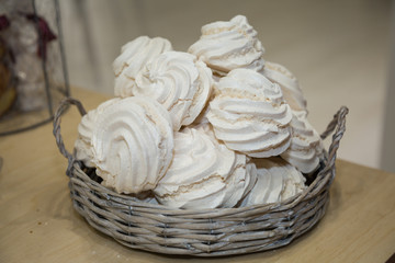 Group of White Meringues in a Wicker Basket