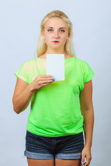 Young blonde girl holds leaflet with copyspace