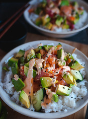 Close-up of California roll sushi bowls on dark background 