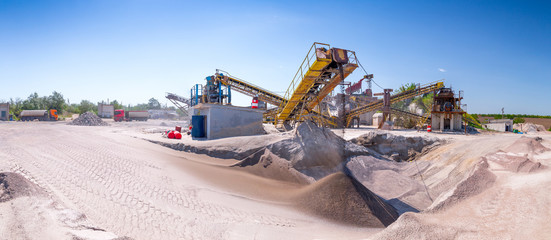 Crushing machinery, cone type rock crusher, conveying crushed granite gravel stone in a quarry open...