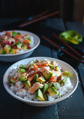 Close-up of California roll sushi bowls on dark background 