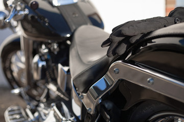 Black gloves on the fender of a motorbike