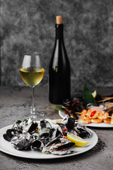 Mussels in copper pot and white wine on stone table.