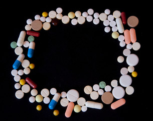 Frame of pills on a dark background with free space for text, top view