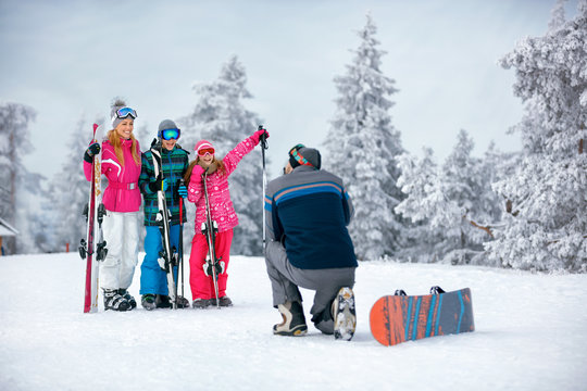 Ski, snow sun and fun - family on ski holiday taking picture