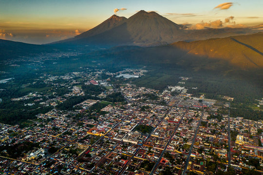 Aerial view of Antigua Guatemala at sunrise with volcanoes