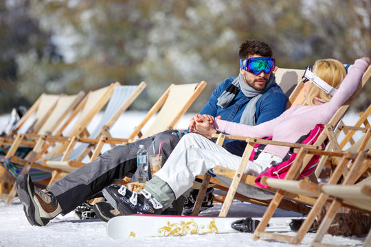 Woman and man resting in sun lounger